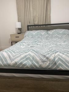 an unmade bed in a bedroom with a night stand at Cozy Private Basement Suite East Windsor in Windsor