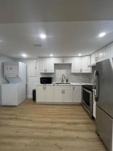 a white kitchen with white cabinets and appliances at Cozy Private Basement Suite East Windsor in Windsor
