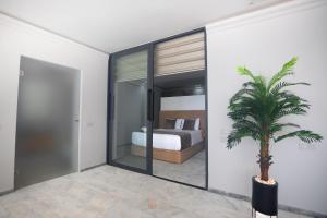 a bedroom with a bed and a palm tree at Playablanca Luxury Beach Apartment First Floor in Tanger in Tangier