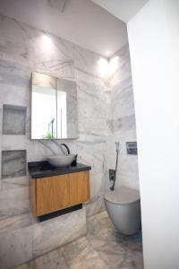 a bathroom with a toilet and a sink and a mirror at Playablanca Luxury Beach Apartment First Floor in Tanger in Tangier