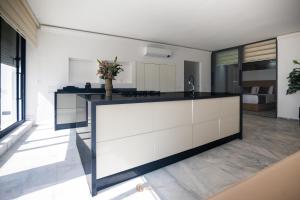 a kitchen with white cabinets and a black counter top at Playablanca Luxury Beach Apartment First Floor in Tanger in Tangier +10 photos