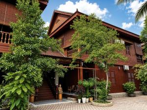 a wooden house with trees in front of it at ASANA Villas in Siem Reap