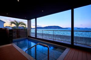 a swimming pool with a view of the water at Villa JacoO-ヴィラじゃこまる- in Sanuki