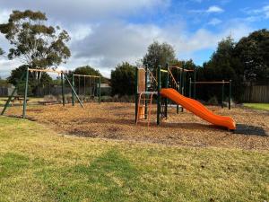 a playground with an orange slide in a park at 2 bedroom private unit with enclosed back yard in Bairnsdale