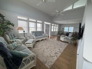 a living room with couches and chairs and a television at Mischief Managed NC in Oak Island
