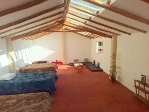 a bedroom with four beds in a room with wooden ceilings at Refugio tierra viva in Cusco