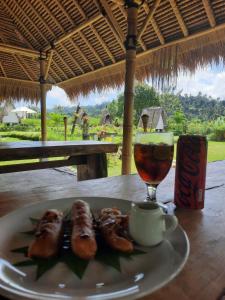 ein Teller mit Essen und ein Getränk auf einem Tisch in der Unterkunft Uma Buug in Karangasem + 59 Fotos