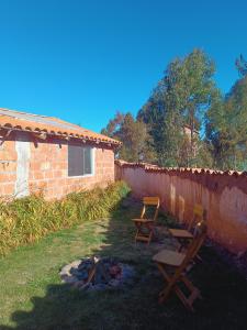 two chairs and a fire pit next to a brick building at Refugio tierra viva in Cusco +7 photos