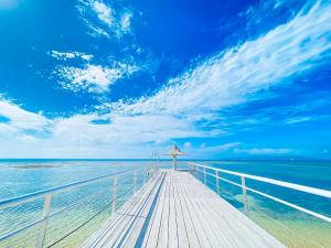 a wooden boardwalk leading into the ocean under a blue sky at フサキリゾート Ishigaki 201 in Ishigaki Island
