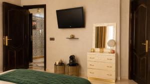 a bedroom with a bed and a television on the wall at Appartement Spacieux 2 Chambres avec vue sur le jardin - Taroudant in Taroudant