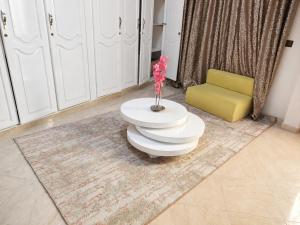 a room with a white table and a yellow chair at Appartement Spacieux 2 Chambres avec vue sur le jardin - Taroudant in Taroudant