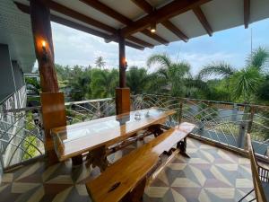 a wooden bench sitting on top of a balcony at Green Field Resort Hotel in Anda