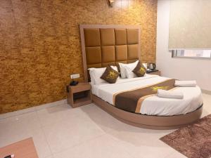 a bedroom with a large bed with a large headboard at the moon palace in Agra