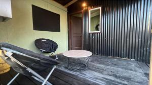 a porch with a table and a chair and a television at Casita Nalca in Chaitén
