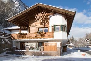 a house with a balcony in the snow at Apartment Ötztal in Tumpen