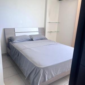 a small bed in a room with white walls at Apartamento Ocean View in La Chumicosa +5 photos