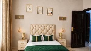 a bedroom with a bed with a green comforter at Appartement Spacieux 2 Chambres avec vue sur le jardin - Taroudant in Taroudant