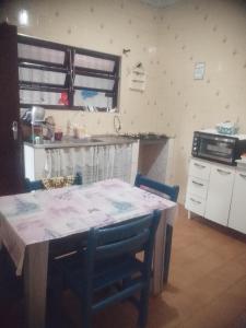 a kitchen with a table with chairs and a stove at Casa Próximo Centro Itanhaém in Itanhaém