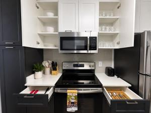 a kitchen with white cabinets and a stove top oven at mamihomes redondo beach in Redondo Beach