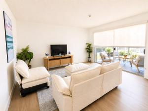a living room with a couch and a tv at mamihomes redondo beach in Redondo Beach