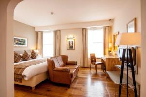 a hotel room with a bed and a chair at ABode Canterbury in Canterbury +37 photos