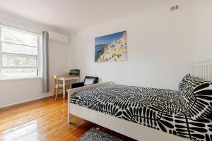 a bedroom with a black and white bed and a desk at Cute and cozy cottage in Northfield