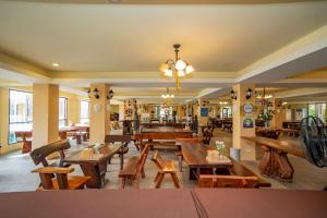 a restaurant with wooden tables and chairs in a room at Wellness World Chiva Khao Yai in Ban Wang Sai