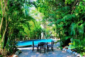 a table and chairs in front of a swimming pool at Wellness World Chiva Khao Yai in Ban Wang Sai