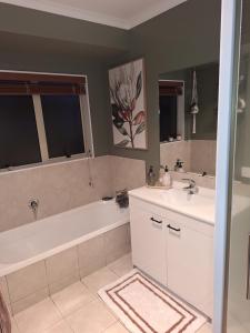 a bathroom with a tub and a sink and a bath tub at Sunset Te Kamo in Whangarei +11 photos