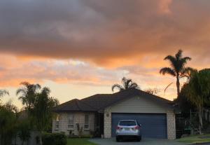 a car parked in front of a house with a garage at Sunset Te Kamo in Whangarei