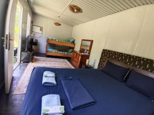 a bedroom with a blue bed with towels on it at Calicoan Surf Retreat unique family room in Guiuan