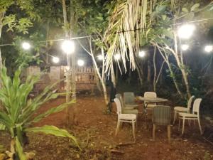 a table and chairs in a garden at night at Calicoan Surf Retreat unique family room in Guiuan