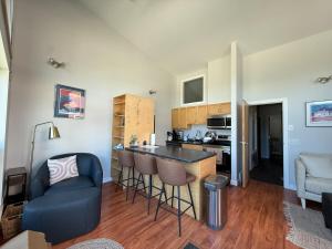 a kitchen and living room with a bar and a couch at The Hanson Hideaway in Whitehorse