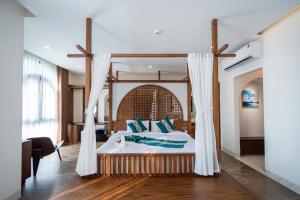 a bedroom with a large bed with white curtains at Cactus Villa in Dong Hoi