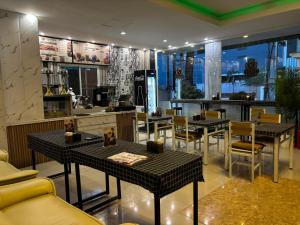a restaurant with tables and chairs and a bar at VENTURA Boutique Residence in Pattaya