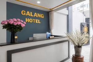 a lobby of a galling hotel with flowers on a counter at GALANG HOTEL in Ho Chi Minh City