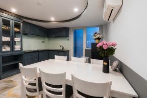 a kitchen with a white table and white chairs at GALANG HOTEL in Ho Chi Minh City