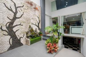 a wall with a tree mural in a store at GALANG HOTEL in Ho Chi Minh City