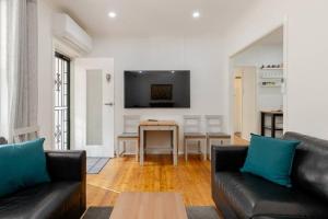 a living room with two black couches and a table at Cute and cozy cottage in Northfield