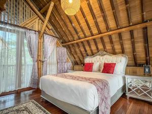a bedroom with a white bed with red pillows at The Kharma Villas Yogyakarta in Yogyakarta +62 photos