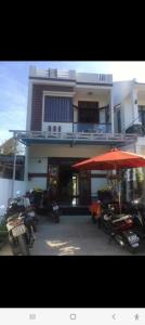 a building with motorcycles parked in front of it with an umbrella at Lockhang homestay in Thanh Ðông (1) +9 photos