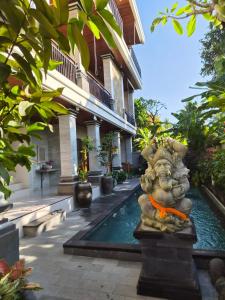 a house with a statue in front of a swimming pool at Lavana Ubud in Ubud