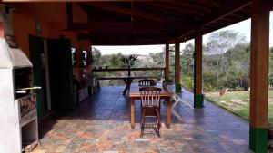 a patio with a table and chairs on a brick floor at Rancho Batatas in Atibaia