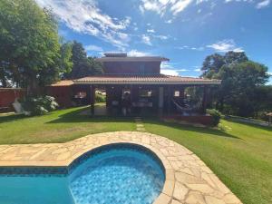 a house with a swimming pool in front of a house at Rancho Batatas in Atibaia