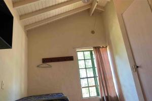 a room with a window and a bed in it at Rancho Batatas in Atibaia