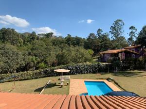 a backyard with a swimming pool and a house at Rancho Batatas in Atibaia