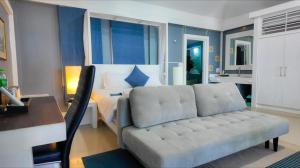 a bedroom with a bed and a couch and a desk at Bann Sunset Cove Krabi I A Hidden Luxury Escape on Had Yao Beach in Krabi