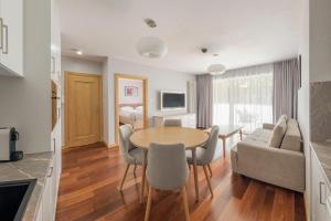 a kitchen and living room with a table and chairs at Apartamenty MAREA in Jurata