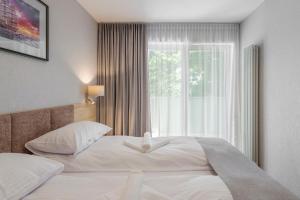 a bedroom with a large bed and a window at Apartamenty MAREA in Jurata