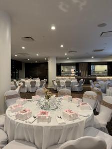 a banquet hall with white tables and white chairs at The Royal Anne Hotel in Kelowna
